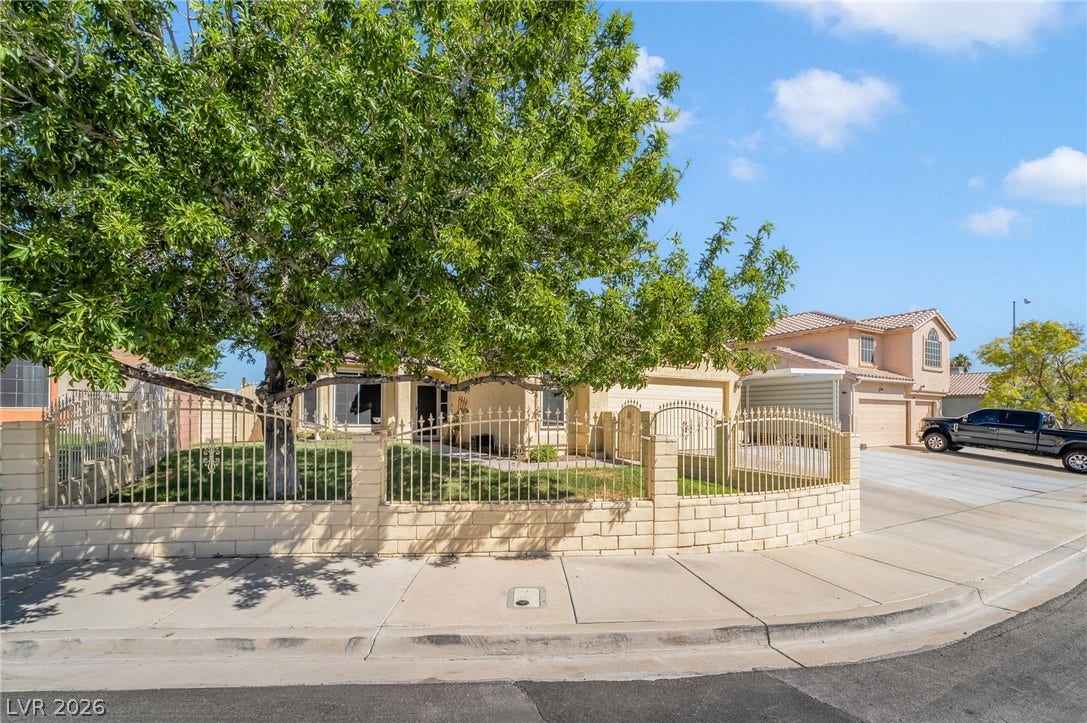 125 Heather Drive, Henderson, NV 89002 A classic stucco home sits on a corner lot behind a secure gated perimeter.