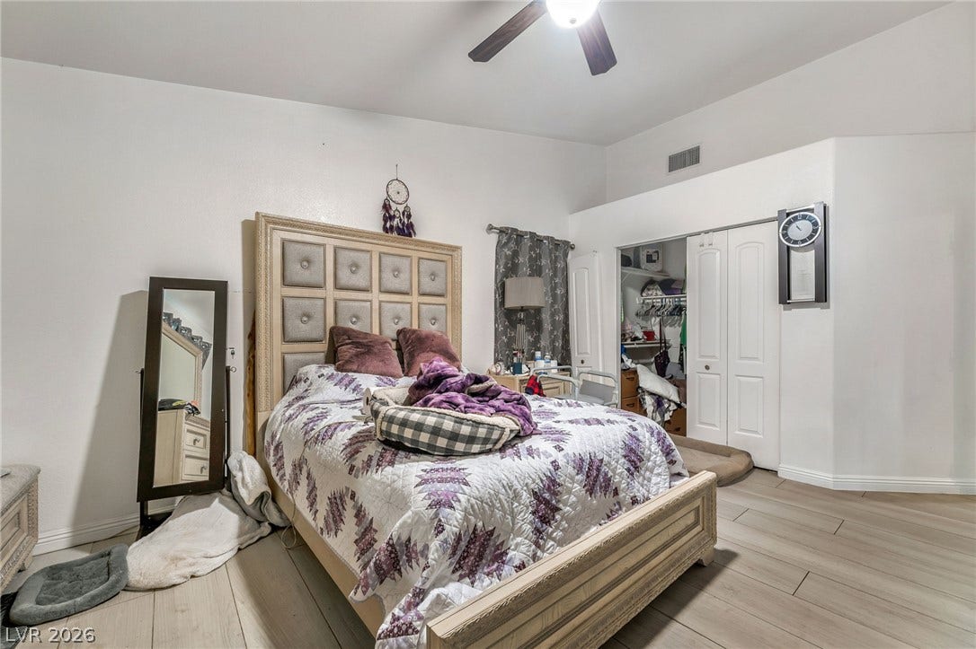125 Heather Drive, Henderson, NV 89002 A spacious bedroom features neutral-toned flooring and an attached closet with folding doors.
