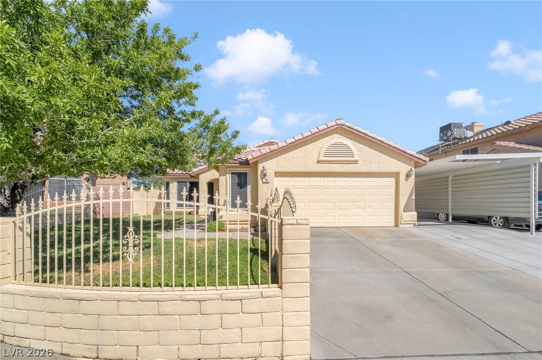 125 Heather Drive, Henderson, NV 89002 Classic stucco exterior pairs with a paved driveway and spanish tile roof under blue skies.