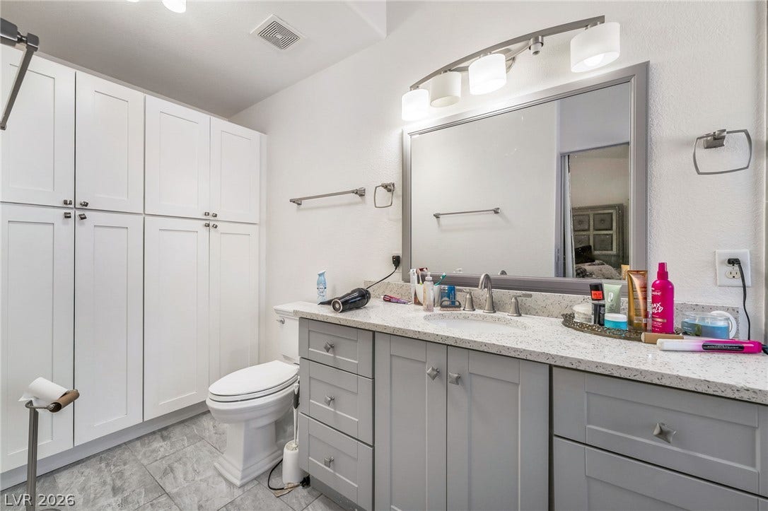 125 Heather Drive, Henderson, NV 89002 Ample built-in cabinetry provides extensive storage alongside a modern stone-topped vanity.