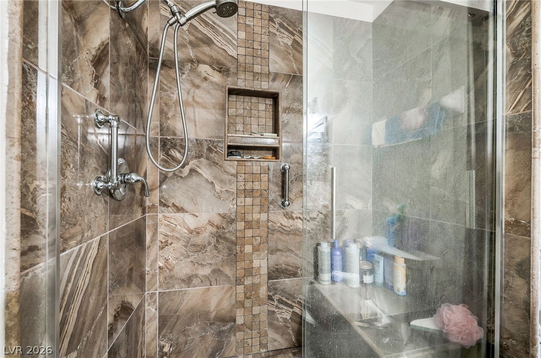 125 Heather Drive, Henderson, NV 89002 Floor-to-ceiling tile work and a glass enclosure define this custom walk-in shower.