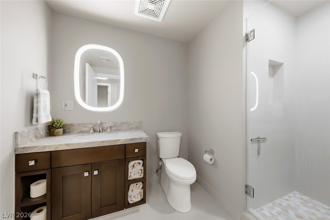 30 Strada Di Villaggio, #151, Henderson, NV 89011 Modern stone countertops and a glass-enclosed shower define this clean, contemporary bathroom.
