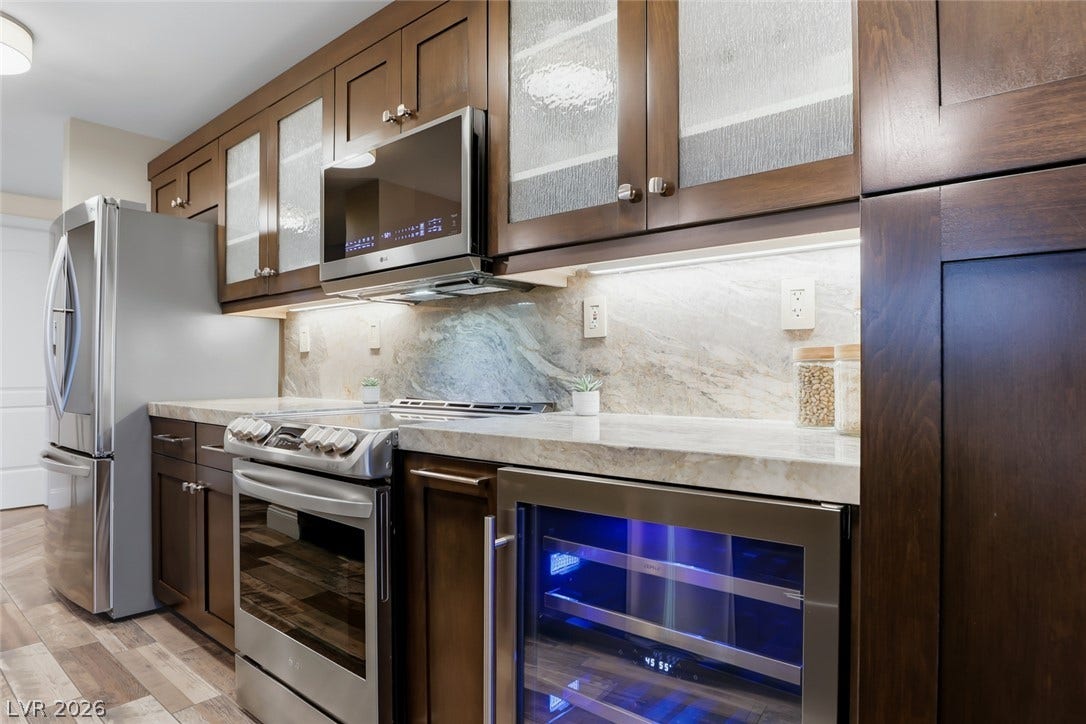 30 Strada Di Villaggio, #151, Henderson, NV 89011 Rich wood cabinets and stone counters create an elegant culinary workspace.