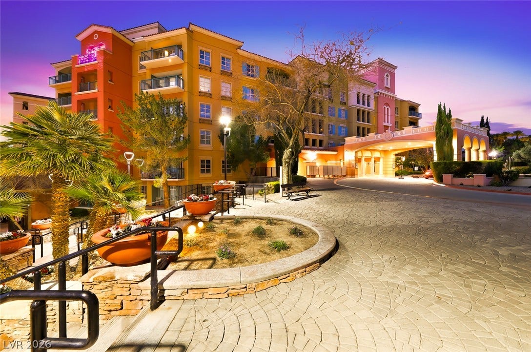 30 Strada Di Villaggio, #151, Henderson, NV 89011 An elegant paved driveway leads to a covered entrance beneath multi-level residential balconies.