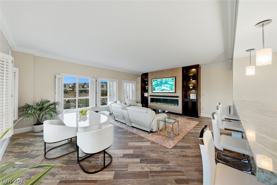 30 Strada Di Villaggio, #151, Henderson, NV 89011 Crown molding frames the open-concept living area featuring rich wood-look flooring and custom built-ins.
