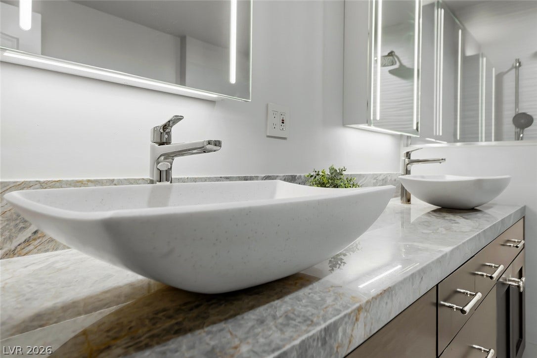 30 Strada Di Villaggio, #151, Henderson, NV 89011 An elegant double vanity features stone countertops and modern vessel sinks.