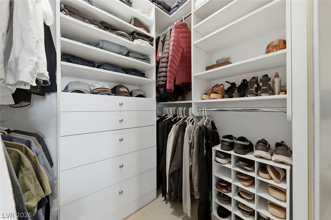 30 Strada Di Villaggio, #151, Henderson, NV 89011 Custom floor-to-ceiling shelving and integrated dresser drawers maximize storage in this carpeted closet.
