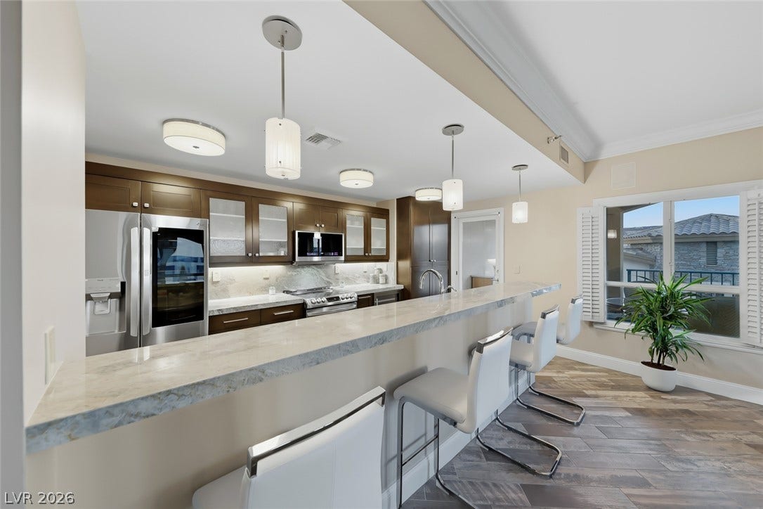30 Strada Di Villaggio, #151, Henderson, NV 89011 Polished stone counters and crown molding accent this updated open culinary space.