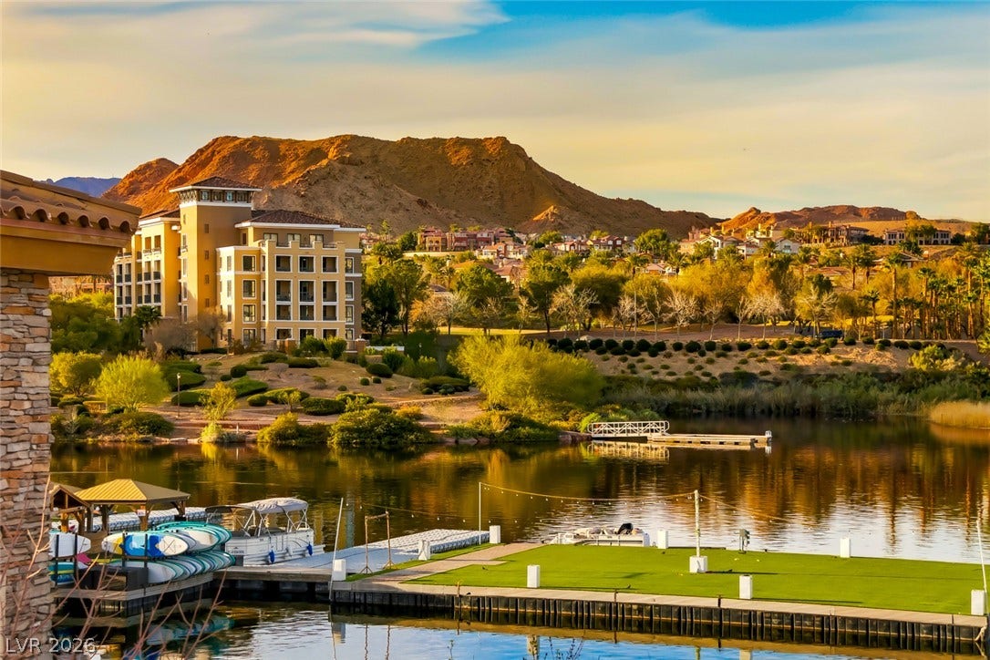 30 Strada Di Villaggio, #151, Henderson, NV 89011 A tranquil lakeside dock looks out over calm water toward distant desert mountains.