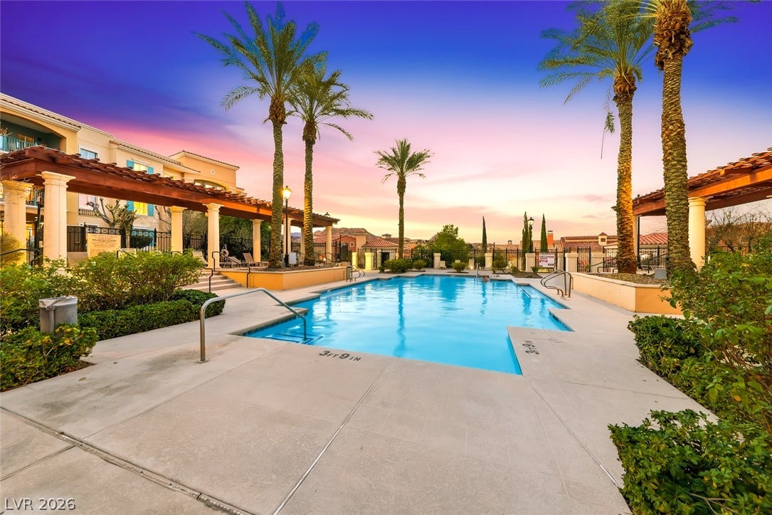 30 Strada Di Villaggio, #151, Henderson, NV 89011 An inviting swimming pool is flanked by towering palm trees and classic shade pergolas.