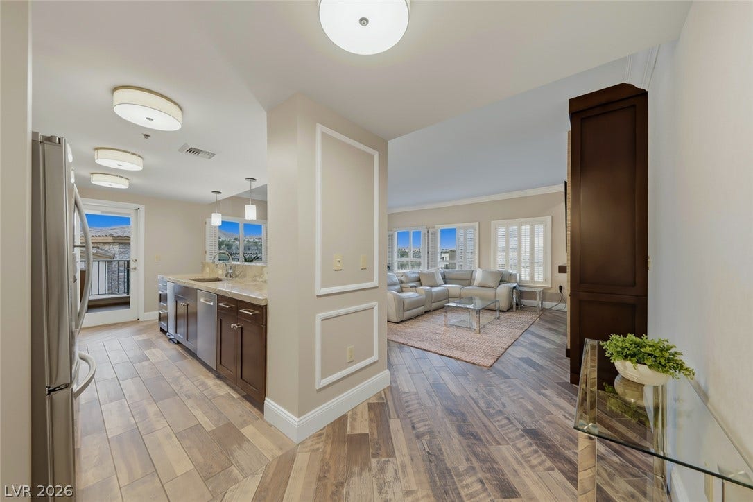 30 Strada Di Villaggio, #151, Henderson, NV 89011 Seamless flow connects the custom kitchen with the adjoining living area over polished plank flooring.