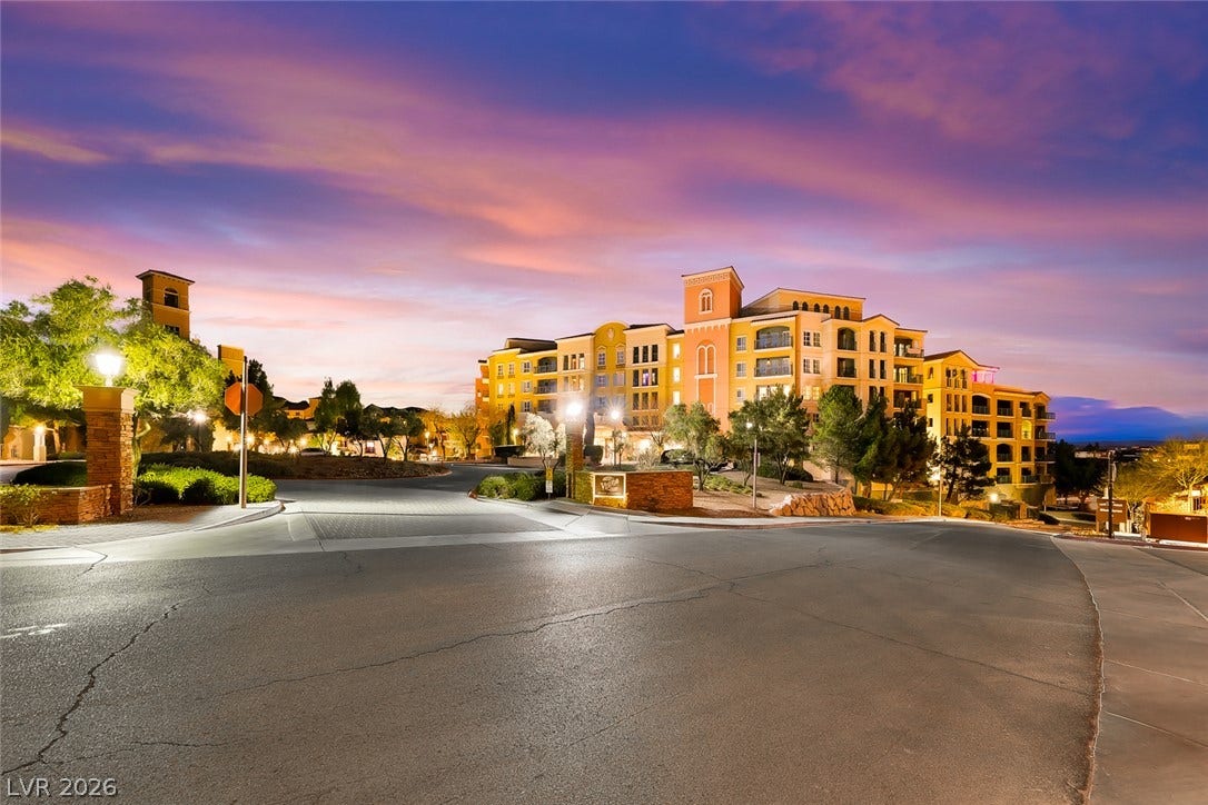 30 Strada Di Villaggio, #151, Henderson, NV 89011 Multi-level Mediterranean-inspired architecture stands elegantly against a dramatic sunset sky.