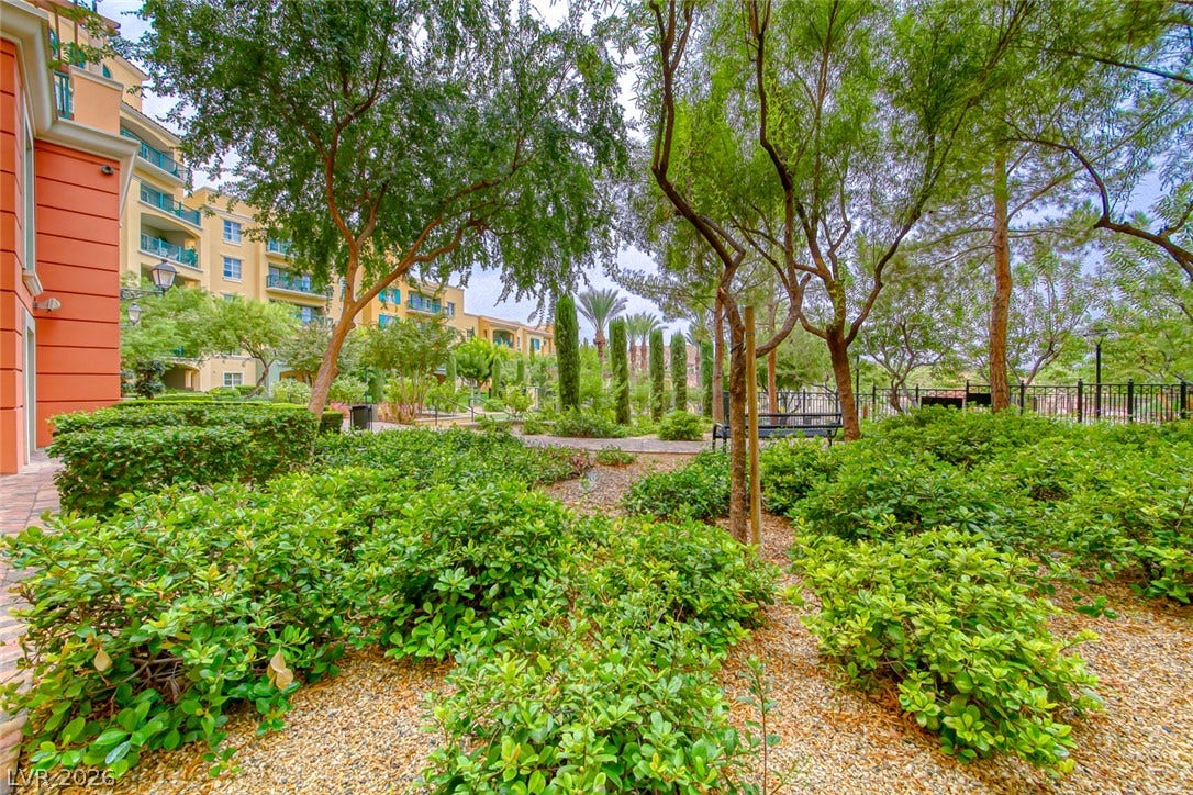 30 Strada Di Villaggio, #151, Henderson, NV 89011 Lush landscaping and mature trees frame this peaceful courtyard pathway adjacent to the residential building.
