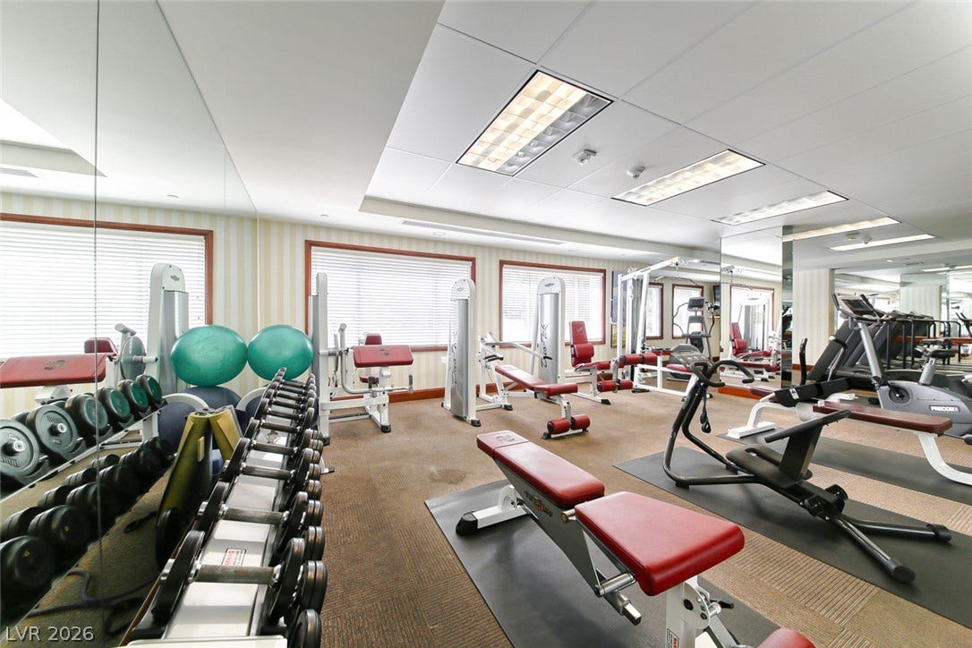 30 Strada Di Villaggio, #151, Henderson, NV 89011 A well-equipped fitness space is highlighted by floor-to-ceiling mirrors and multiple windows.
