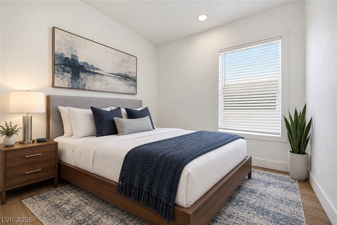 A tall window guides light across the hardwood floor of this tranquil bedroom space.