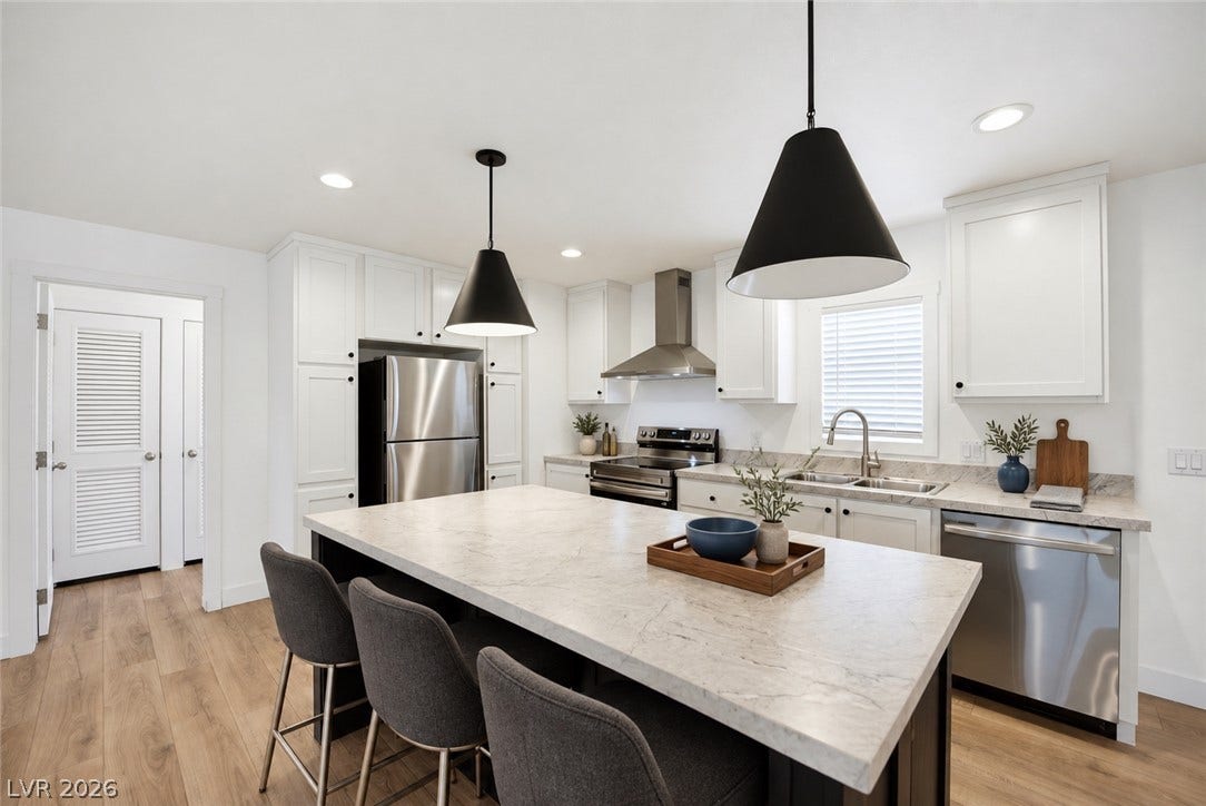 An expansive central island with stone countertops anchors this modern culinary space.