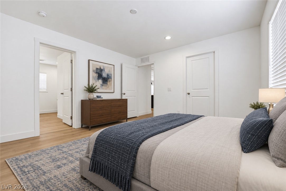 Recessed lighting and warm wood flooring enhance this modern bedroom design.