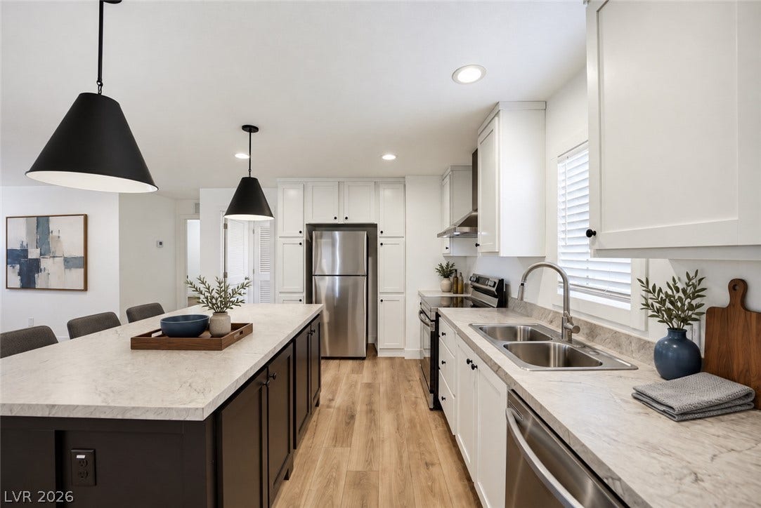 Crisp white cabinetry and a generous island anchor this modern, light-filled workspace.