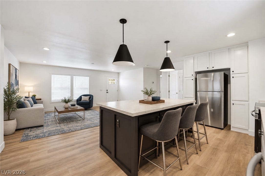 Gleaming hardwood floors and a spacious island anchor this light-filled modern open-concept space.
