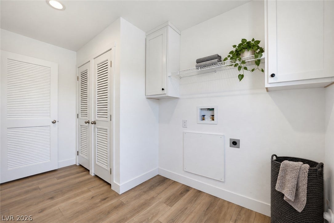 Gleaming wood floors and built-in white cabinets anchor this functional utility space.