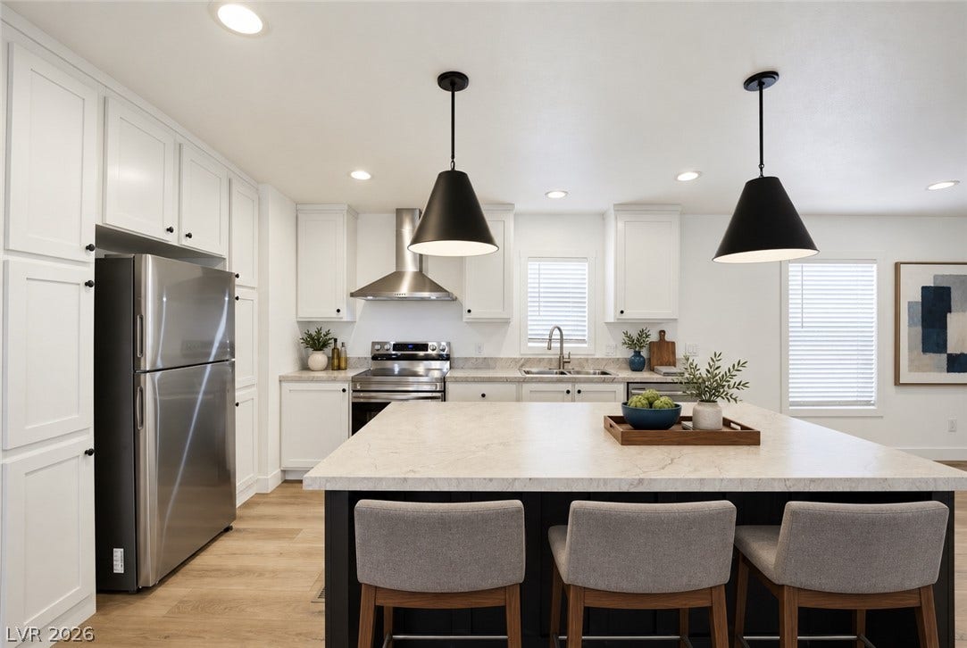 Polished stone countertops pair beautifully with crisp shaker cabinetry and light oak hardwood floors.