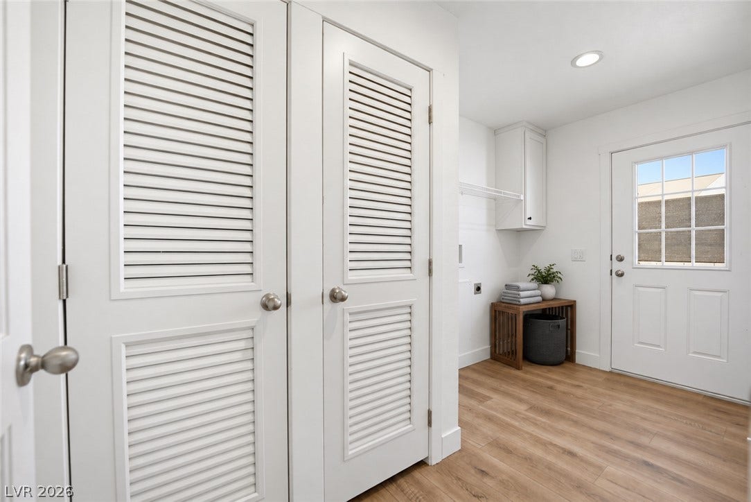 Louvered closet doors and smooth plank flooring guide the way to a bright exit.