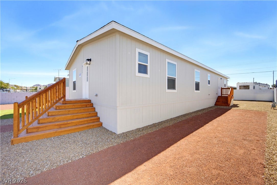 Sturdy wooden stairs lead to the entrance of this modern, low-maintenance home.