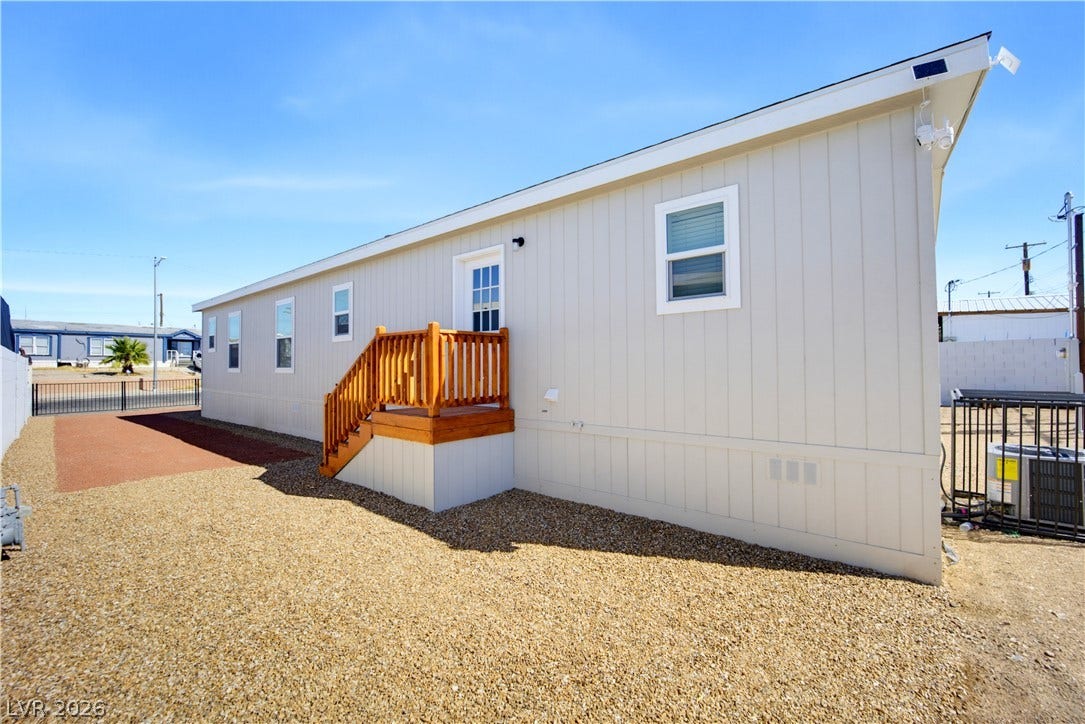 Clean vertical siding and a neat gravel yard define this low-maintenance exterior.