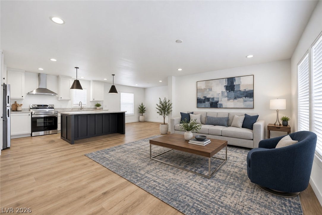 An open floorplan seamlessly connects the central kitchen island to the bright living space.