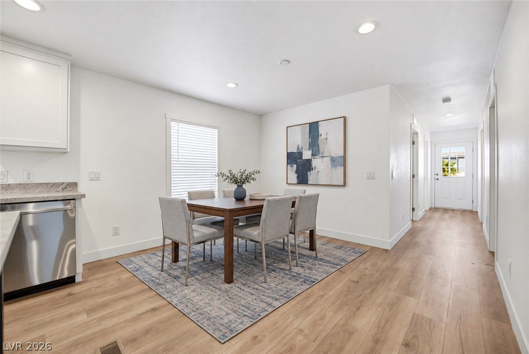 Gleaming wood-look floors anchor this open-concept dining area and adjacent hallway.