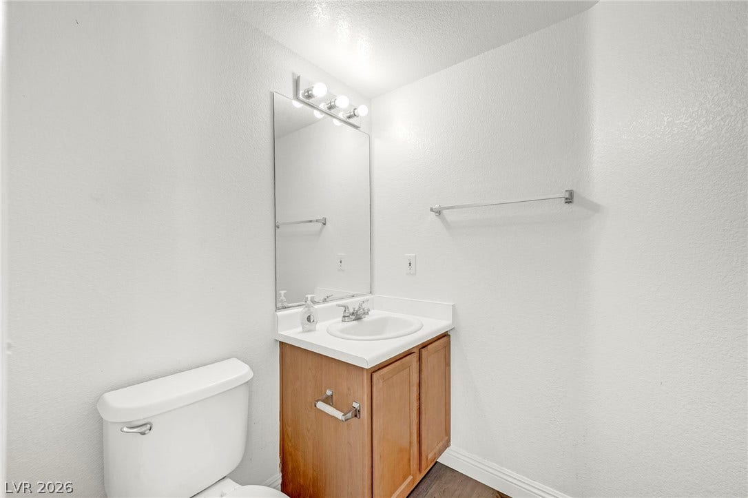 511 Armenian Place, Henderson, NV 89052 A classic wooden vanity anchors this functional powder room setup.