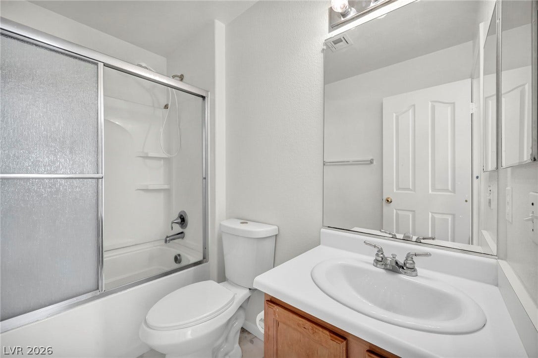 511 Armenian Place, Henderson, NV 89052 Functional bathroom features a glass-enclosed shower and tub combination next to a classic vanity.