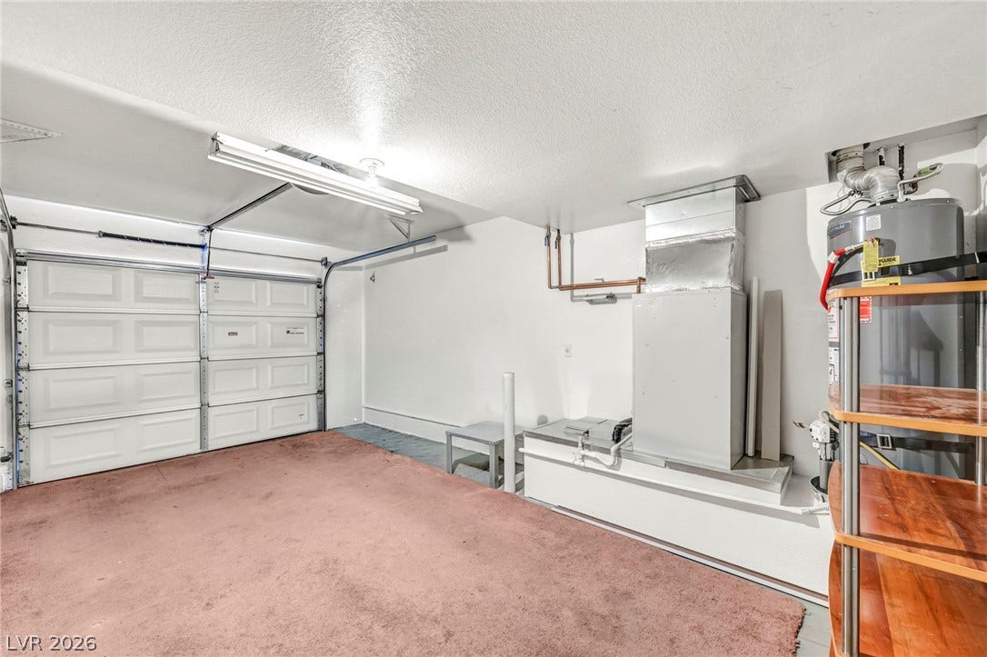 511 Armenian Place, Henderson, NV 89052 An attached garage features concrete flooring alongside functional household utility installations.