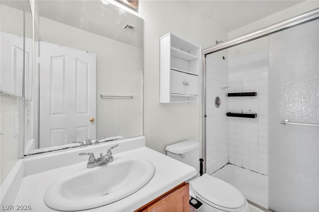 511 Armenian Place, Henderson, NV 89052 White tiled walk-in shower sits adjacent to a classic single vanity.