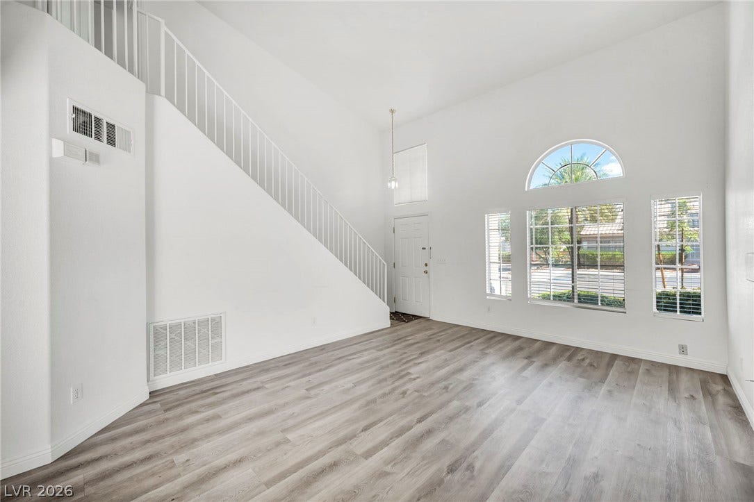 511 Armenian Place, Henderson, NV 89052 Towering ceilings and wood-look flooring anchor this airy entryway and living space.