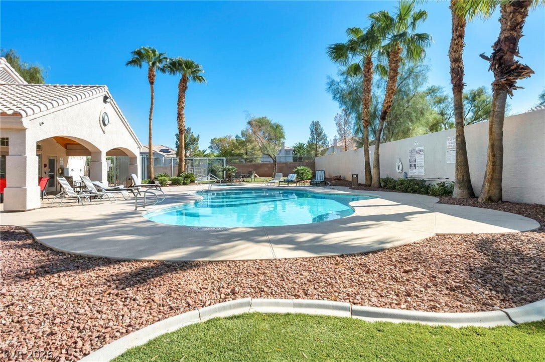 511 Armenian Place, Henderson, NV 89052 Mature palm trees and a concrete deck surround this sparkling blue swimming pool.