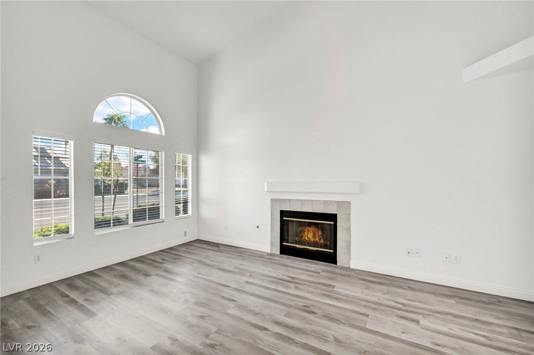 511 Armenian Place, Henderson, NV 89052 Soaring vaulted ceilings and a cozy tiled fireplace define this light-filled living space.