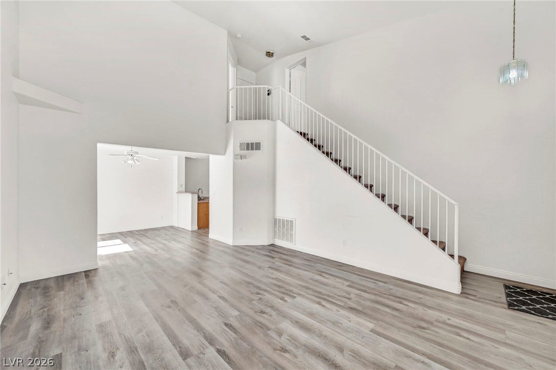 511 Armenian Place, Henderson, NV 89052 Crisp white walls frame a sweeping staircase above smooth wood-toned flooring.