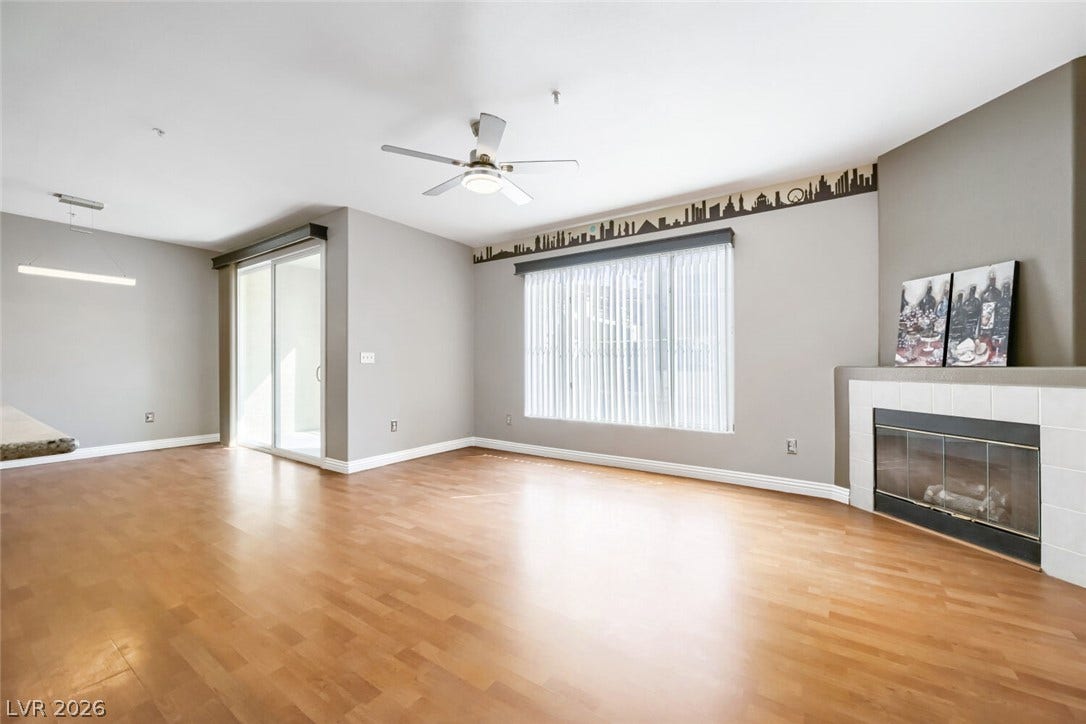 7173 S Durango Drive, #212, Las Vegas, NV 89113 Polished wood floors and a classic tile fireplace anchor this airy, open living area.