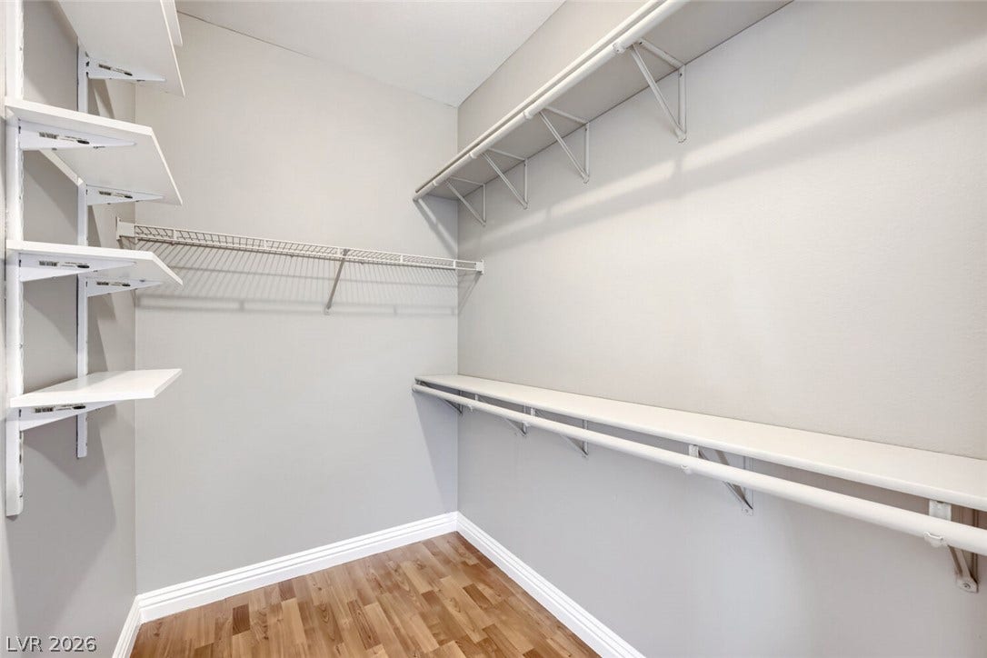 7173 S Durango Drive, #212, Las Vegas, NV 89113 Ample storage options define this neat walk-in closet featuring handsome wood floors.