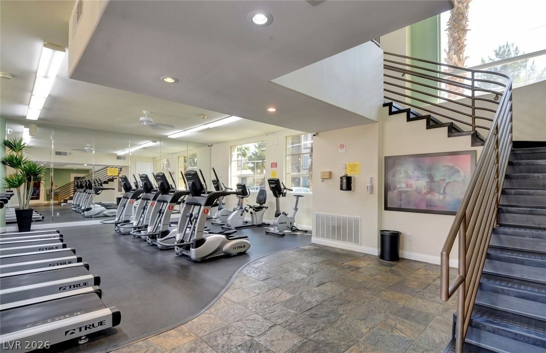 7173 S Durango Drive, #212, Las Vegas, NV 89113 Stone tile flooring and recessed lighting accent this modern fitness space with high ceilings.
