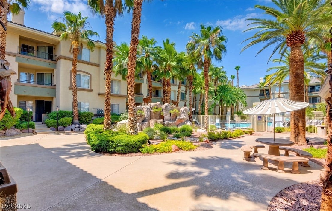 7173 S Durango Drive, #212, Las Vegas, NV 89113 Lush palm trees surround the paved courtyard and community pool area of this residential complex.