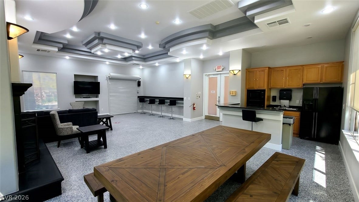 7173 S Durango Drive, #212, Las Vegas, NV 89113 Multi-tiered tray ceilings and recessed lighting crown this expansive recreation room with a wet bar.