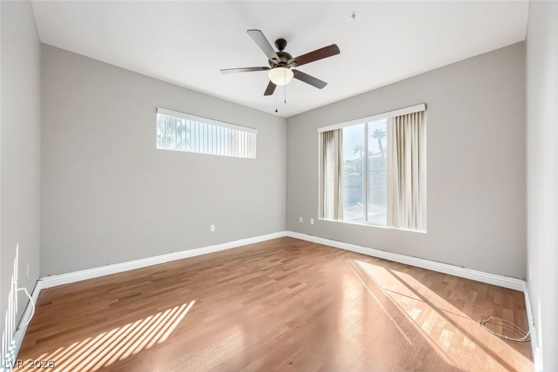 7173 S Durango Drive, #212, Las Vegas, NV 89113 Warm wood flooring and natural light define this versatile bedroom space.