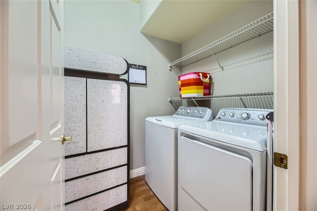 7173 S Durango Drive, #212, Las Vegas, NV 89113 An organized laundry closet features wood flooring and built-in shelving overhead.