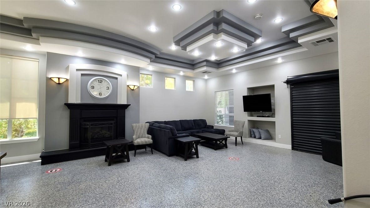 7173 S Durango Drive, #212, Las Vegas, NV 89113 A striking tiered tray ceiling and handsome fireplace highlight this versatile living space.