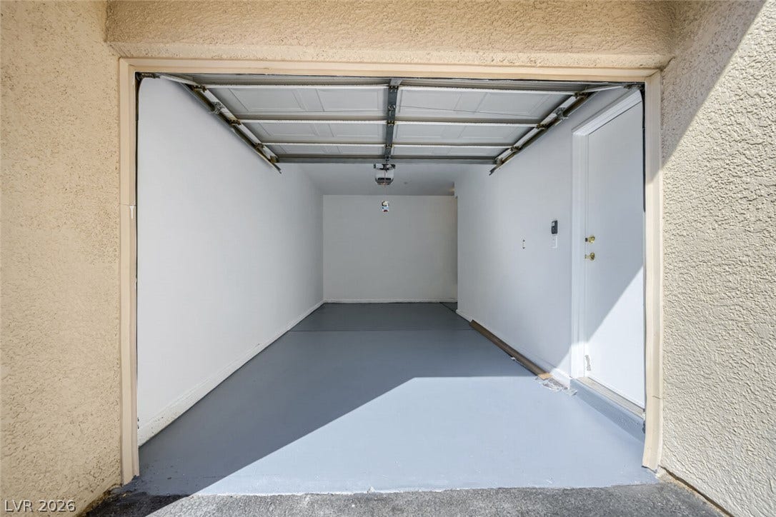 7173 S Durango Drive, #212, Las Vegas, NV 89113 A spacious garage features clean finished walls and a newly painted floor.