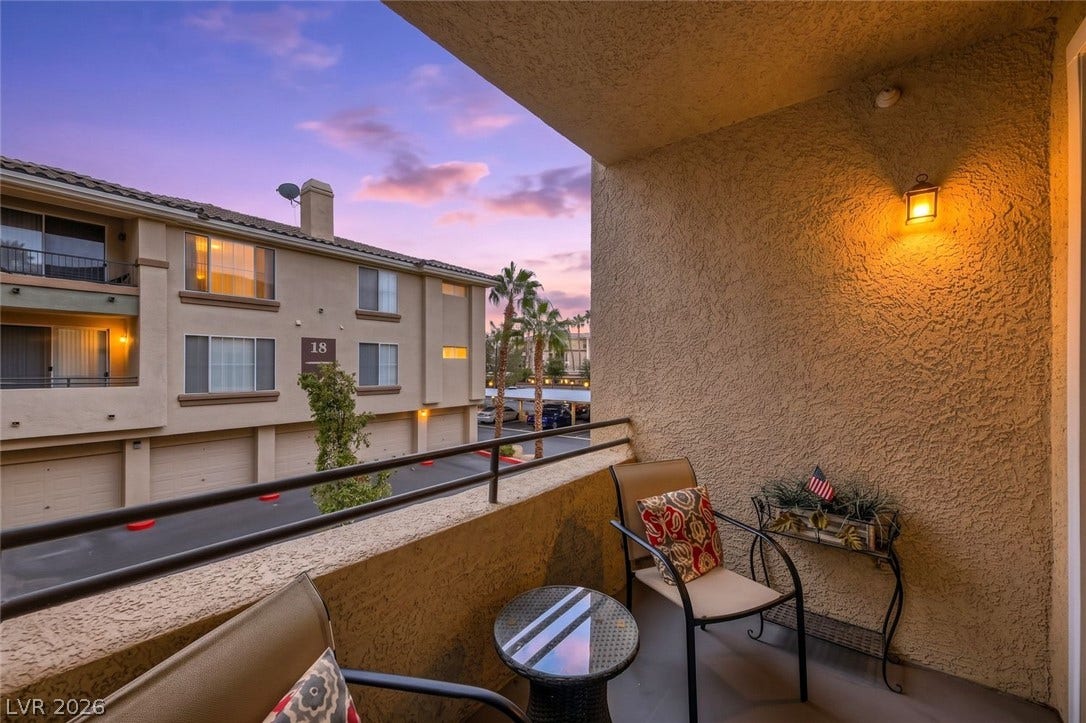 7173 S Durango Drive, #212, Las Vegas, NV 89113 An elevated private balcony looks out over the surrounding neighborhood at sunset.