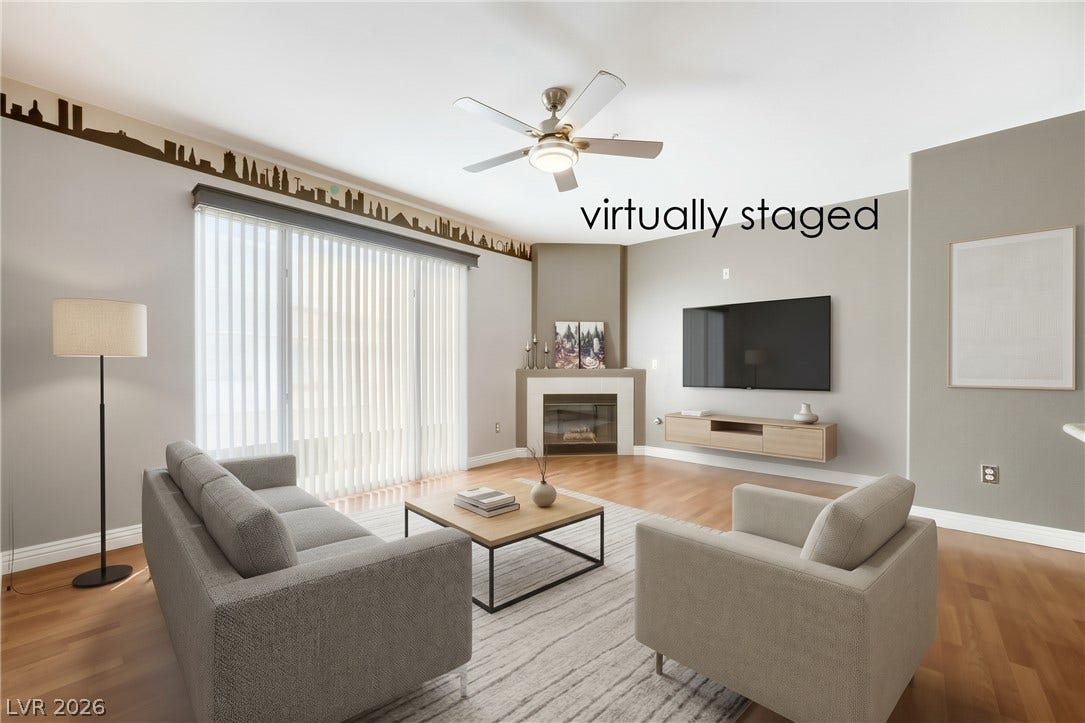 7173 S Durango Drive, #212, Las Vegas, NV 89113 Warm wood flooring and a classic corner fireplace anchor this comfortable living room.