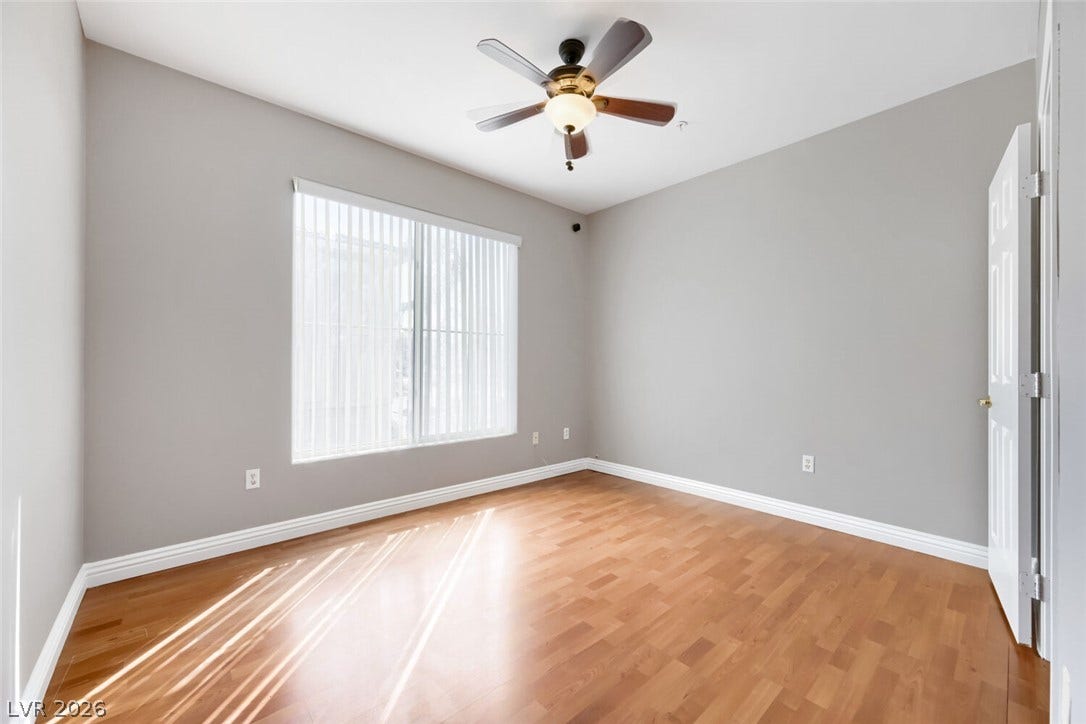 7173 S Durango Drive, #212, Las Vegas, NV 89113 Warm wood flooring and clean baseboards anchor this versatile bedroom space.